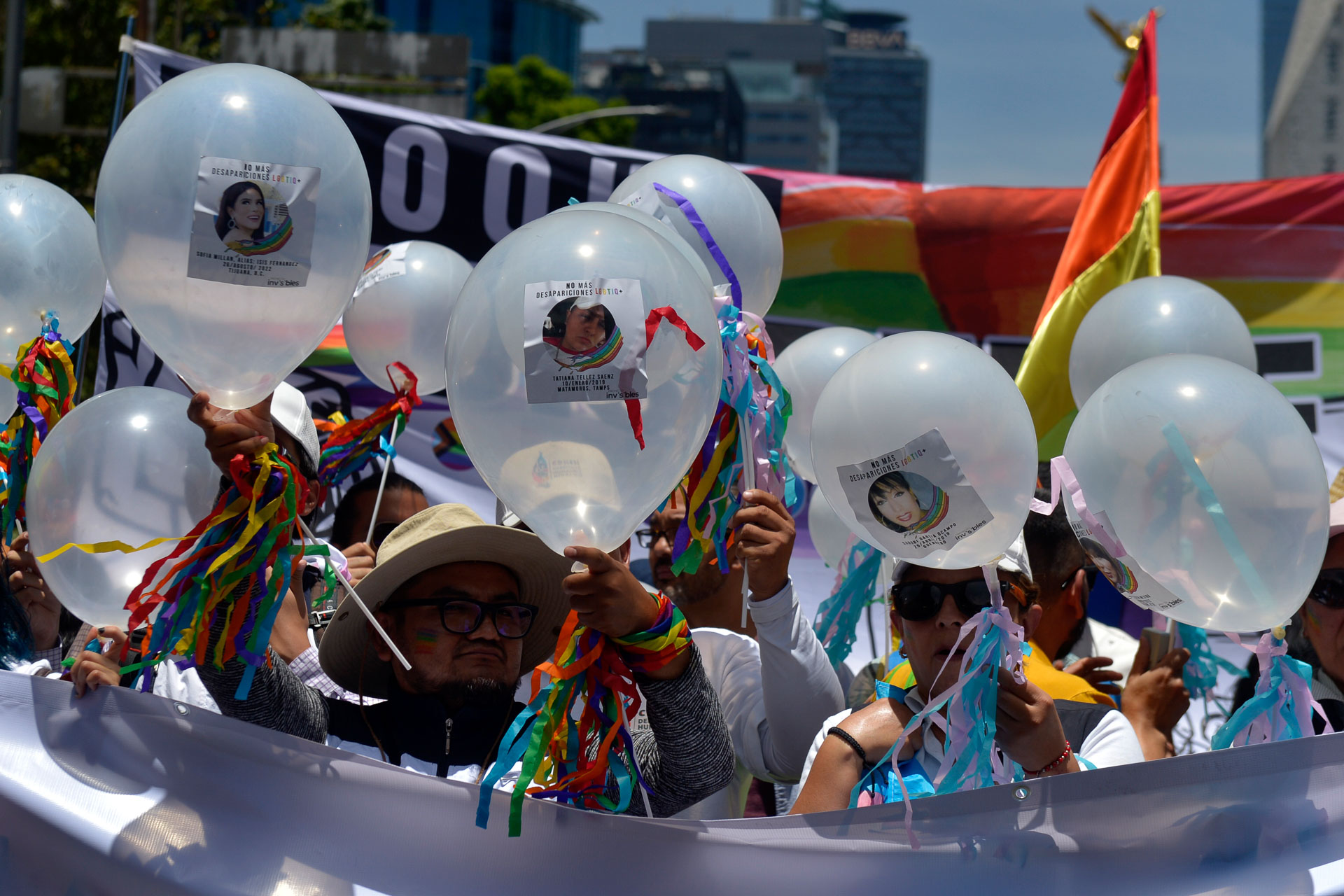 Los globos blancos con fotografías de personas desaparecidas se mezclaron con los colores festivos durante el recorrido.