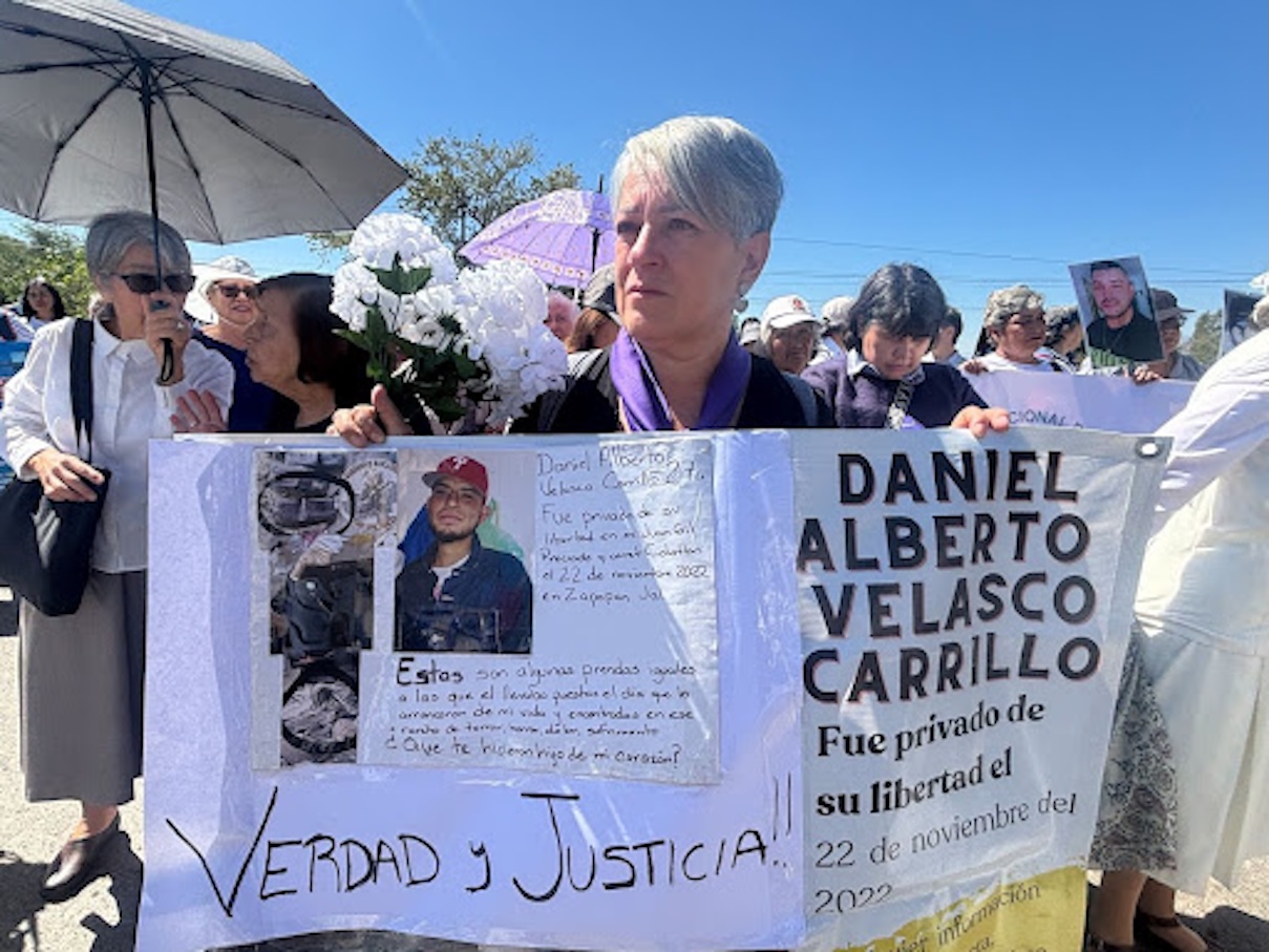 Carmen Carrillo llevó a Teuchitlán una pancarta con el nombre de su hijo desaparecido e imágenes de las prendas y objetos que le hacen pensar que sus restos están en el rancho Izaguirre. Foto: Marcela Turati